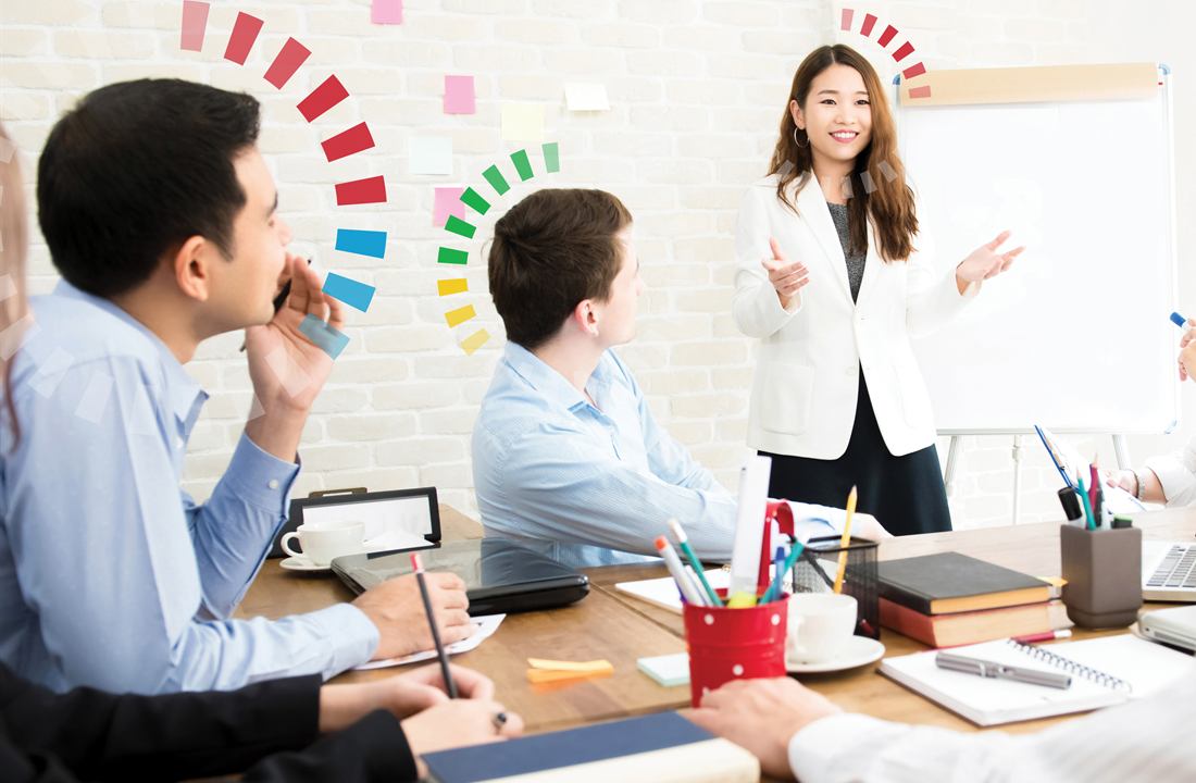 Eine Führungskraft spricht vor ihrem Team im Besprechungsraum